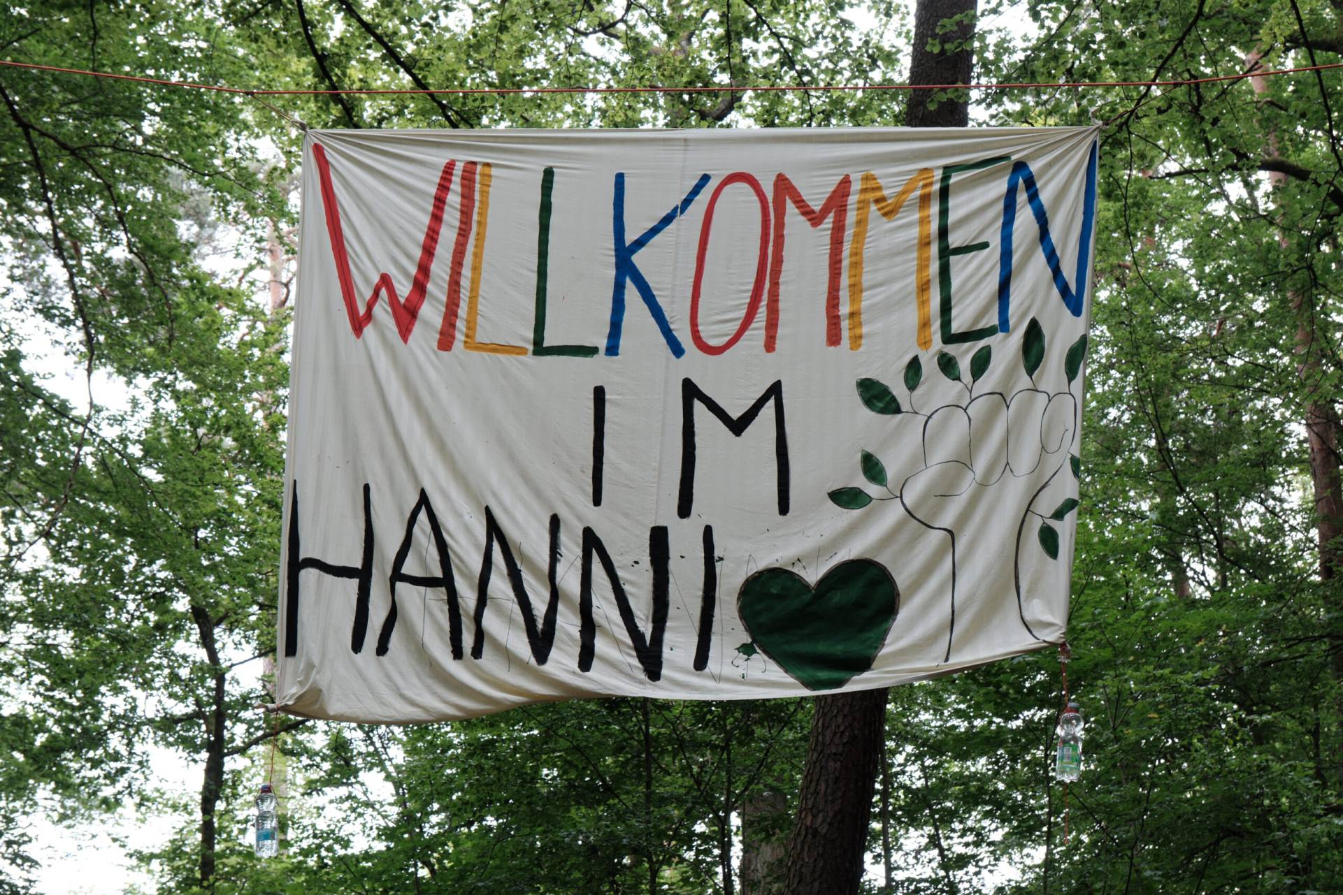 Banner hängt zwischen Bäumen