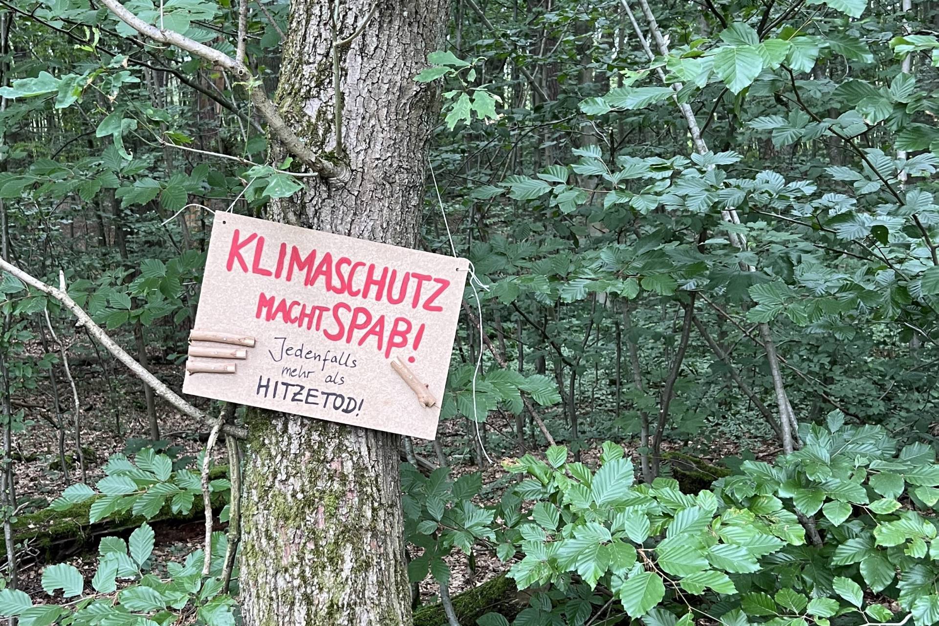 Baumschild 'Klimaschutz macht Spaß! Jedenfalls mehr als Hitzetod!'